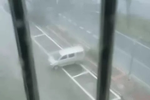 Những chiếc ô tô bị gió mạnh cuốn đi.