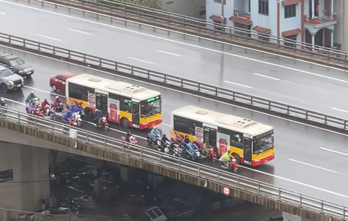 Các tài xế xe ô tô, đặc biệt là xe khách, đã quyết định giảm tốc độ, tạo thành một 'lá chắn' di động để chắn gió, giúp các phương tiện nhỏ hơn, như xe máy, có thể vượt qua cầu an toàn.