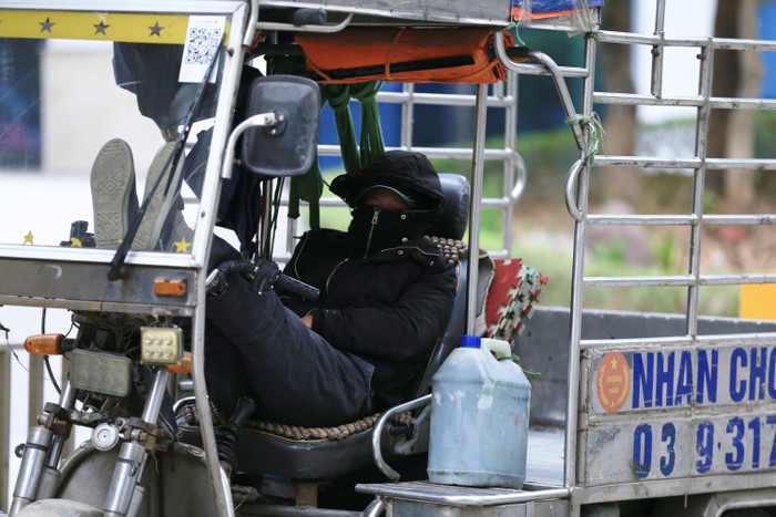Tài xế xe ba gác co ro trong cái lạnh tại Hà Nội