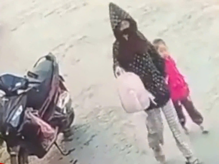 Cô gái vào trường mầm non mầm non dẫn cháu bé ra ngoài. Ảnh: Camera an ninh