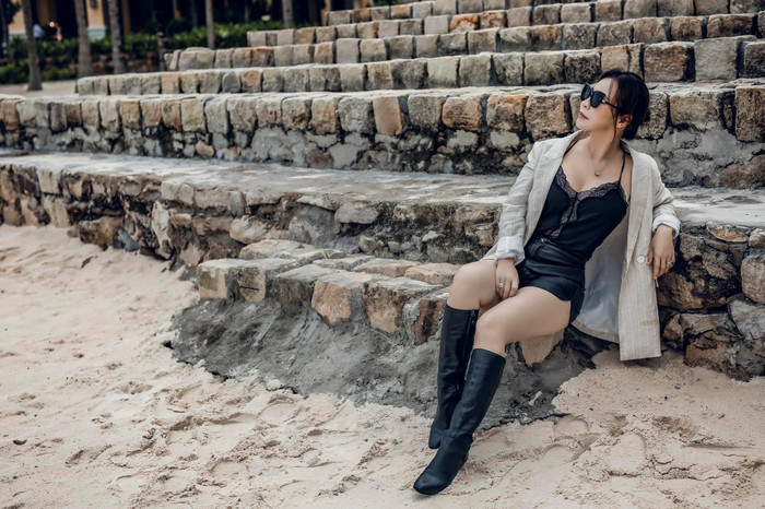 Thi thoảng, vợ Quý Bình theo đuổi phong cách năng động, cá tính. Cô diện bản phối gồm áo hai dây, quần short. Ngọc Tiền khéo léo sơ vin áo, tôn lên vòng eo nhỏ xíu. Vợ Quý Bình còn phối cùng một số món phụ kiện như giày boots da cao cổ, kính mát. Đặc biệt, tổng thể outfit của Ngọc Tiền tăng độ gợi cảm nhờ chi tiết xẻ sâu, phối ren ở phần áo hai dây, để lộ lấp ló đường chân ngực. (Ảnh: FBNV)