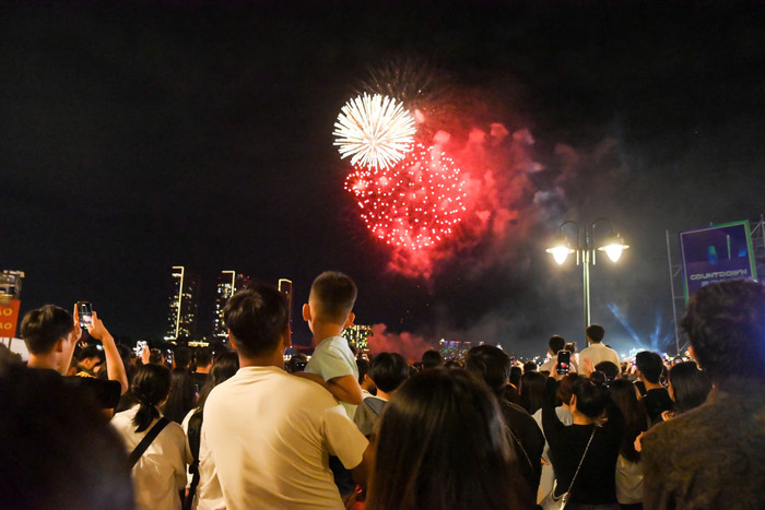 Người dân xem pháo hoa mừng năm mới 2025 ở Công viên Bến Bạch Đằng (TPHCM).