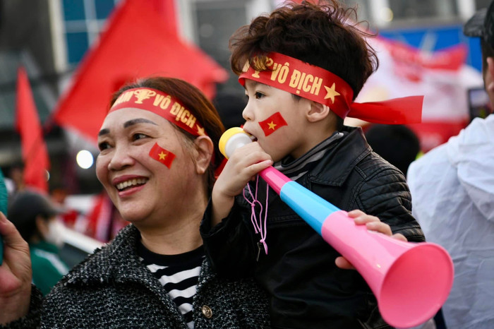 Hai bà cháu đi cổ vũ tuyển Việt Nam với băng rôn vô địch. Ảnh: FAT