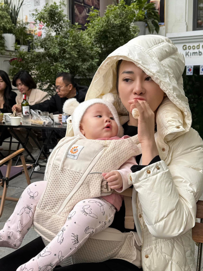 Phương Oanh vô tư ăn vặt khi con gái Jenny đang nhìn theo mẹ. Ảnh: FBNV