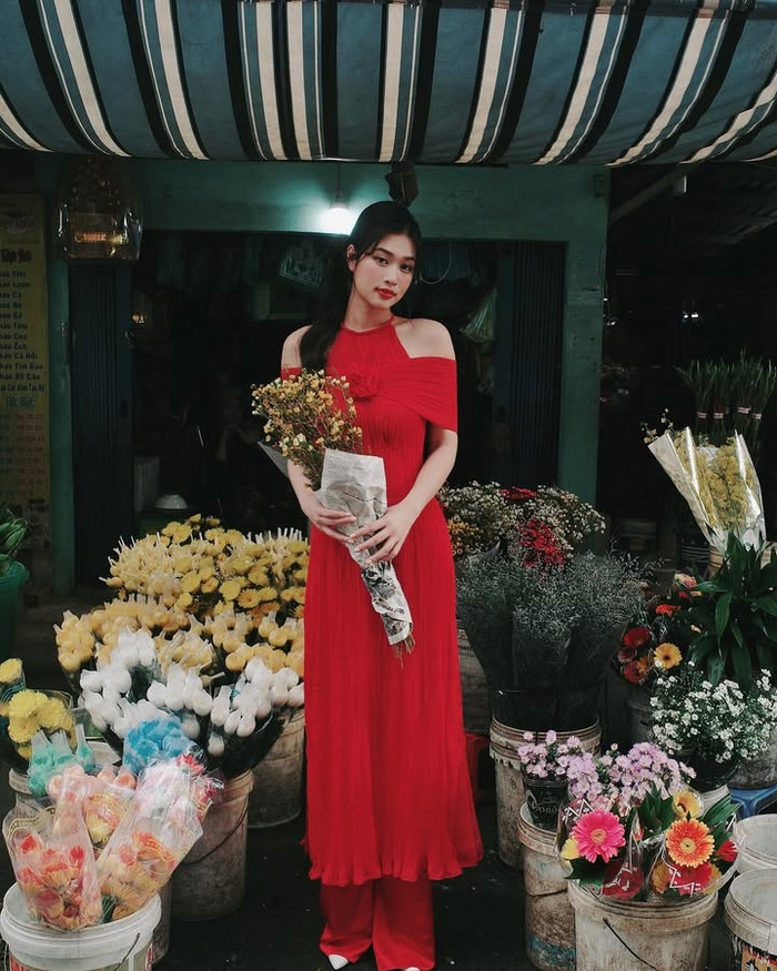 Hoa hậu Đoàn Thiên Ân 'nhuộm đỏ' thời trang ngày Tết với mẫu áo dài trễ vai, để lộ phần xương quai xanh sắc nét, tạo sự thu hút. Cựu Hoa hậu Hòa bình Việt Nam không quên 'trưng dụng' lối trang điểm đậm, nhấn nhá bằng phần son môi đỏ, đồng điệu với màu sắc của trang phục. (Ảnh: FBNV)