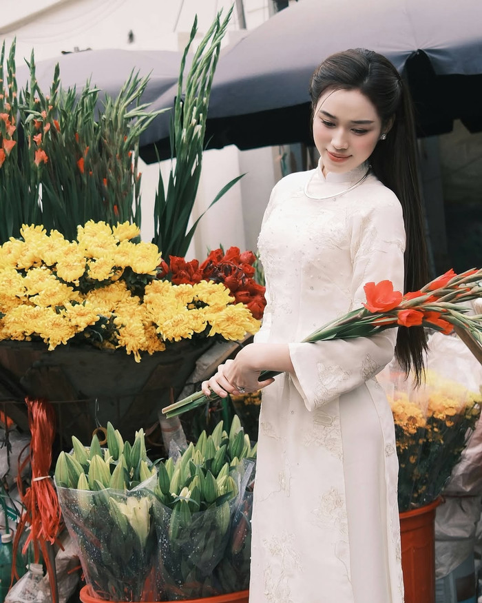 Khác với nhiều mỹ nhân của Vbiz, Hoa hậu Đỗ Thị Hà lại 'lăng xê' kiểu áo dài truyền thống. Trang phục cô lựa chọn mang tông màu trắng tinh khôi, thêu nổi họa tiết hoa và được điểm xuyến dàn cườm lấp lánh. Về phụ kiện, Hoa hậu Đỗ Thị Hà phối cùng chiếc vòng cổ ánh bạc. Trong tạo hình này, cựu Hoa hậu Việt Nam ghi điểm với sắc vóc dịu dàng và nền nã. (Ảnh: FBNV)