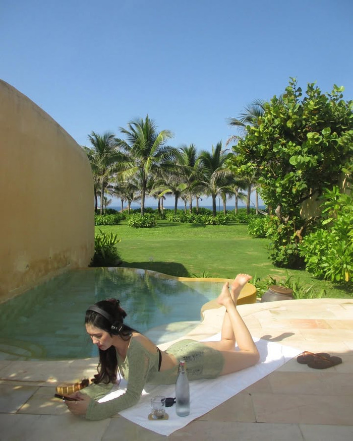 Váy len cắt khoét hiểm hóc cũng là thiết kế thời trang yêu thích của vợ Thành Chung. Cô tiếp tục phối nó với bikini hai mảnh màu đen. Về phụ kiện, vợ Thành Chung lựa chọn tai nghe chụp tai thời thượng, mang đậm phong cách cá tính. (Ảnh: FBNV)