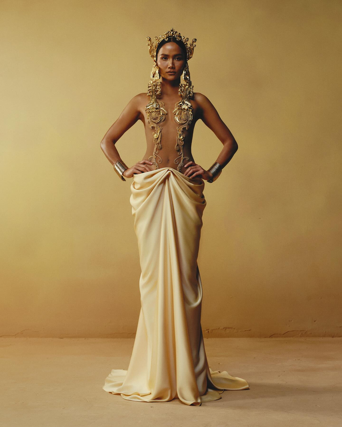 Mới đây, H'Hen Niê gây chú ý khi khoe gần hết cơ thể trong thiết kế mang tên 'Draping Dress'. Trang phục có phom dáng dài thanh lịch, nổi bật bởi các đường draping mềm mại ôm sát cơ thể, tạo sự uyển chuyển và sang trọng. 