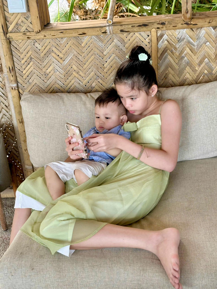 Dù mới chỉ 13 tuổi, nhưng bé Mia đã ra dáng chị cả khi phụ giúp ba mẹ chăm sóc em trai. (Ảnh: FBNV)