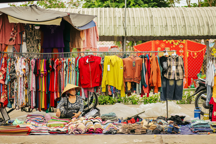 Một tiểu thương bán buôn quần áo dành cho mọi lứa tuổi, giới tính.
