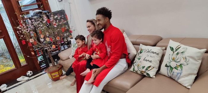 Cả gia đình anh – từ vợ đến hai cậu con trai nhỏ – đều diện áo dài đỏ đồng bộ, cùng ngồi quây quần bên nhau bên cành đào khoe sắc. Bầu không khí gia đình toát lên sự ấm cúng và vui vẻ, như chính tinh thần ngày Tết cổ truyền. Ảnh: Nam Định FC