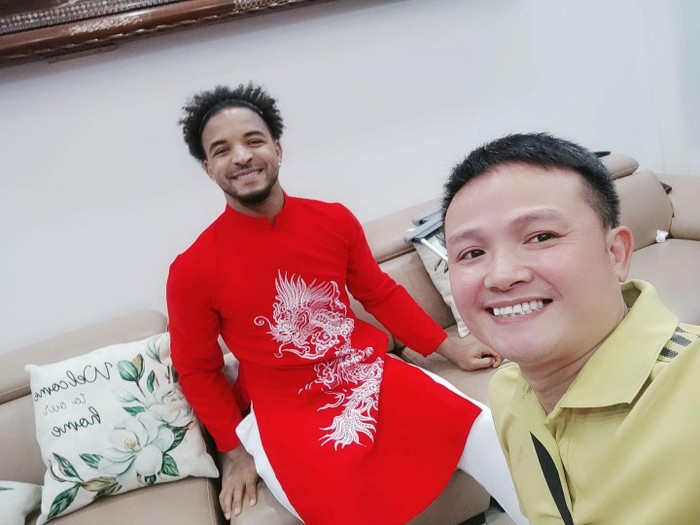 Hình ảnh đầu tiên ghi lại khoảnh khắc Xuân Son trong bộ áo dài đỏ thêu họa tiết rồng, nụ cười tươi sáng hiện rõ trên gương mặt. Bên cạnh anh là bạn bè, những người luôn đồng hành và gắn bó. Ảnh: Nam Định FC