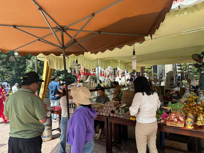 Người dân mua hương, hoa, lễ vật để vào chùa dâng lễ. Ảnh: Minh Anh