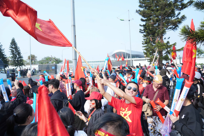 Cổ động viên tuyển Việt Nam mang Quốc kì, kèn, trống đón chào đội tuyển Việt Nam về nước.