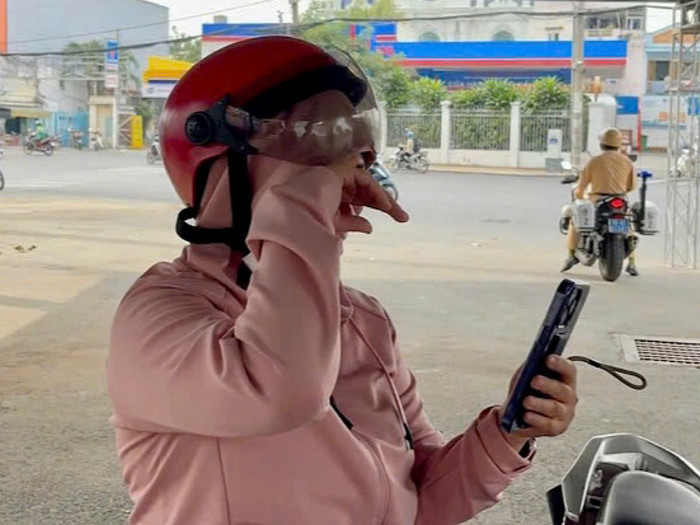 Chị T. khóc nức nở khi bị cảnh sát phạt lỗi leo vỉa hè. Ảnh: NLĐ