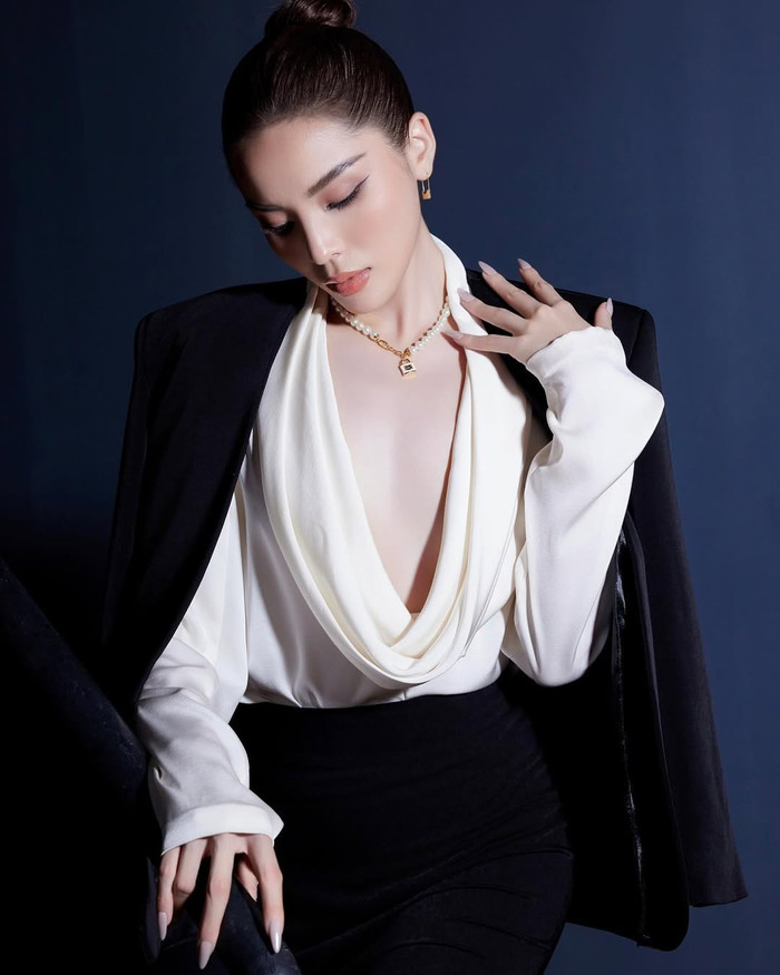 Trong một khoảnh khắc được đăng tải trên trang cá nhân, Hoa hậu Kỳ Duyên ghi điểm với tạo hình đậm chất 'nữ tổng tài' khi diện nguyên cây vest đen. Song, nàng hậu vẫn khéo léo kết hợp với mẫu áo sơ mi lụa, chất liệu mềm mại ở phía trong để tạo điểm nhấn. Đặc biệt, item này sở hữu đường xẻ sâu đến tận hông và Hoa hậu Kỳ Duyên dường như phải 'trưng dụng' mốt không nội y nóng bỏng. (Ảnh: FBNV)