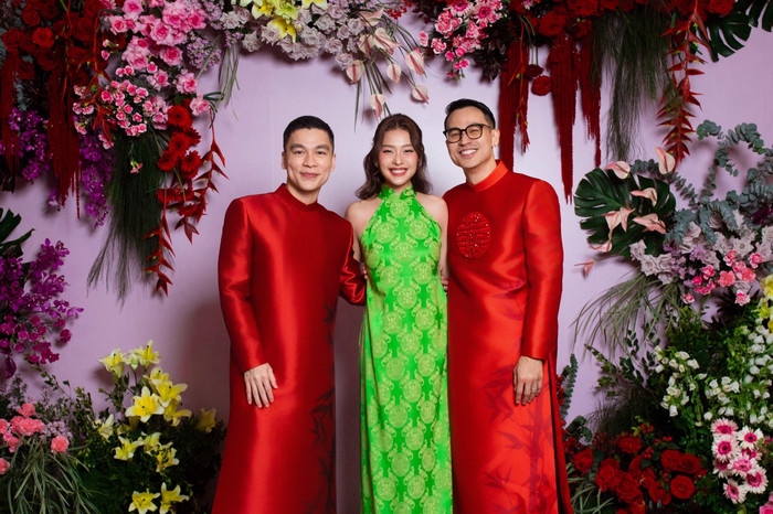 Diễn viên Khả Ngân rạng rỡ với mẫu áo dài cách tân cổ yếm màu xanh lá rực rỡ. Adrian Anh Tuấn (trái) và người bạn đời xuất hiện đón khách trong trang phục áo dài.