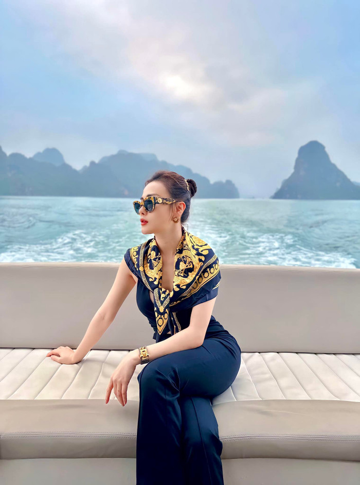 Ngoài những mẫu bikini nhỏ xíu hay váy áo xẻ sâu, Phương Oanh còn ưu ái mẫu jumpsuit dài, ôm sát vóc dáng. Thiết kế này tôn lên thân hình tựa 'đồng hồ cát' của nữ diễn viên. Để tăng độ sang chảnh, Phương Oanh dát thêm dàn phụ kiện với họa tiết màu vàng đồng sang trọng. Trong đó có mẫu khăn lụa quàng cổ với mức giá hơn 14 triệu đồng, kính mắt hơn 5 triệu đồng và khuyên tai tròn cỡ lớn hơn 9 triệu đồng. (Ảnh: FBNV)