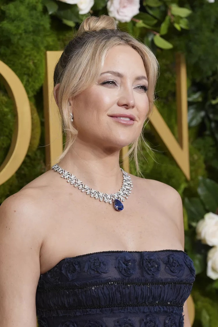 Kate Hudson tỏa sáng với kiểu tóc búi xoắn cao được tạo hình tỉ mỉ bởi nhà tạo mẫu Marcus Frances. Phần mái xéo nhẹ nhàng không chỉ giúp tôn lên khuôn mặt cô mà còn là lời tri ân ngọt ngào dành cho mẹ cô, huyền thoại Goldie Hawn.
