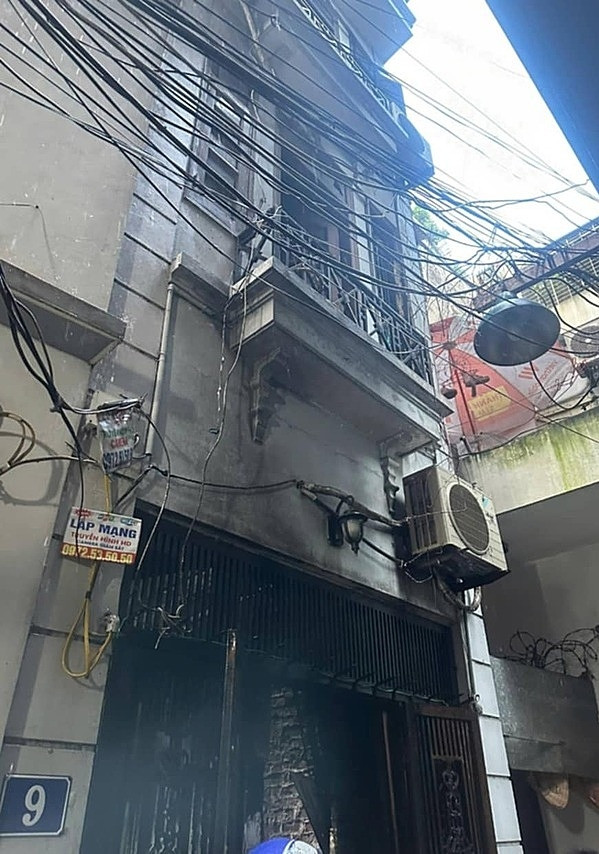 Căn nhà 4 tầng, 1 tum nằm sâu trong ngõ với mặt tiền chưa đầy 2m hiện lên đen sạm. Lớp vữa tường bong tróc, để lộ ra những viên gạch xám xịt. Cửa sắt, cửa kính tầng 1 biến dạng hoàn toàn do nhiệt độ cao. (Ảnh: VnExpress)