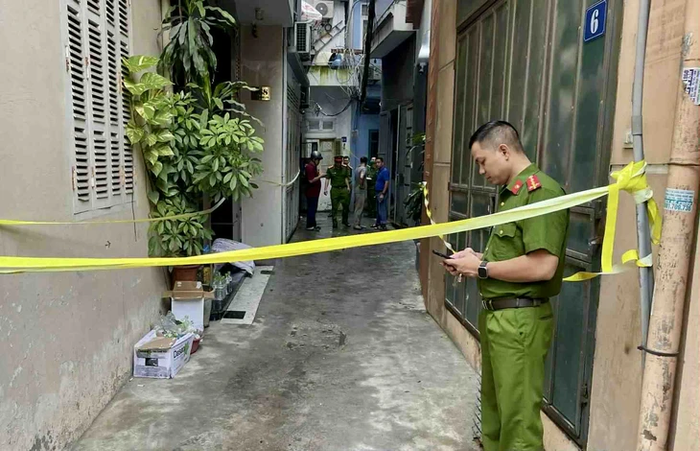Lực lượng chức năng đã thiết lập hàng rào vây kín các lối vào ngôi nhà số 9, hẻm 12, ngách 17 để phục vụ công tác khám nghiệm. Sự im lặng bao trùm khu vực vốn chật hẹp, thay cho tiếng kêu cứu khẩn thiết lúc rạng sáng. (Ảnh: Báo Tuổi Trẻ)