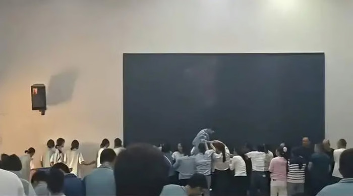 Đoạn video gây sốc lan truyền cho thấy cảnh học sinh trèo qua lưng cha mẹ với sự giúp đỡ của các bạn cùng lớp. Ảnh: QQ.com 