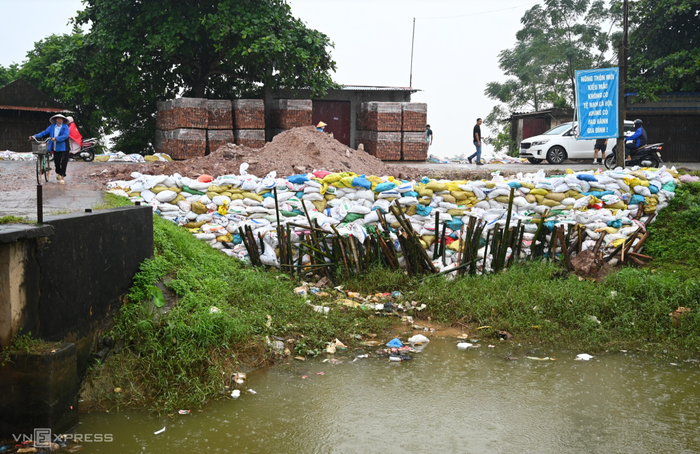 Đê tả Cầu đoạn qua xã Xuân Cẩm có 15 m bị sạt lở, chính quyền đã xử lý bước một bằng cách đóng cọc tre rồi gia cố bằng các bao tải cát. (Nguồn: VnExpress)