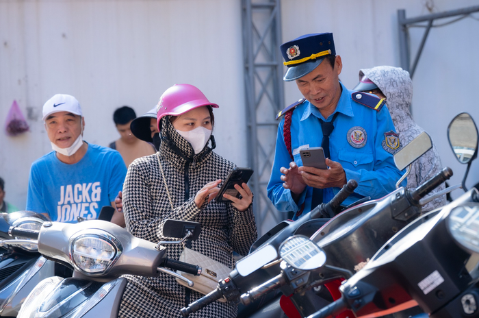 Bảo vệ tại cửa hàng vàng hướng dẫn người dân để xe đúng vị trí, các thức lấy số thứ tự. (Nguồn: Đời sống & Pháp luật)