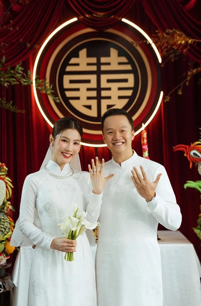 Vợ chồng diễn viên Diễm My 9X chọn áo dài trắng thêu chim phụng trong ngày cưới. (Ảnh FBNV)