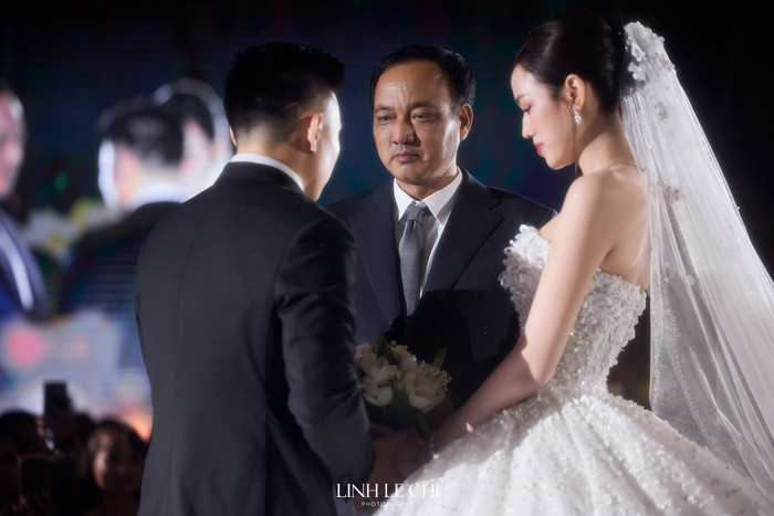 Bố ruột Đỗ Thị Hà nắm tay con gái tiến vào lễ đường, trao cho chú rể khiến nhiều người xúc động. (Ảnh Linh Lê Chí)