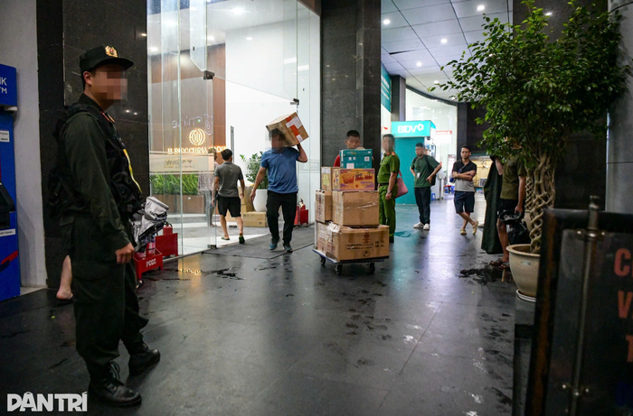 Nhiều thùng tài liệu được chuyển ra xe dưới sự giám sát của cảnh sát. (Nguồn: Dân trí)