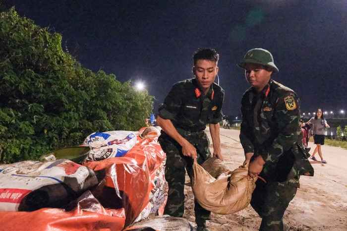 Lực lượng quân đội triển khai dọc tuyến đê Đẩu Hàn (Bắc Ninh) để gia cố đê khi nước sông Cầu lên cao tối 8/10. (Nguồn: Tuổi Trẻ Online) 