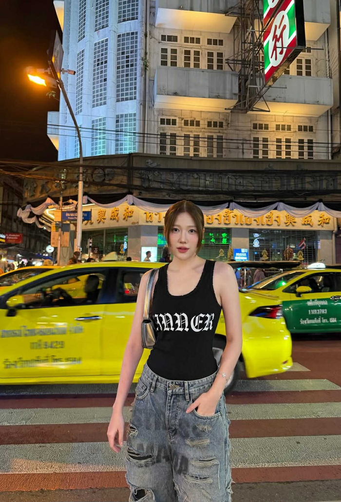 Uyển Ân diện áo tank top đen ôm dáng, kết hợp quần jeans rộng bụi bặm (Ảnh: ISNV).