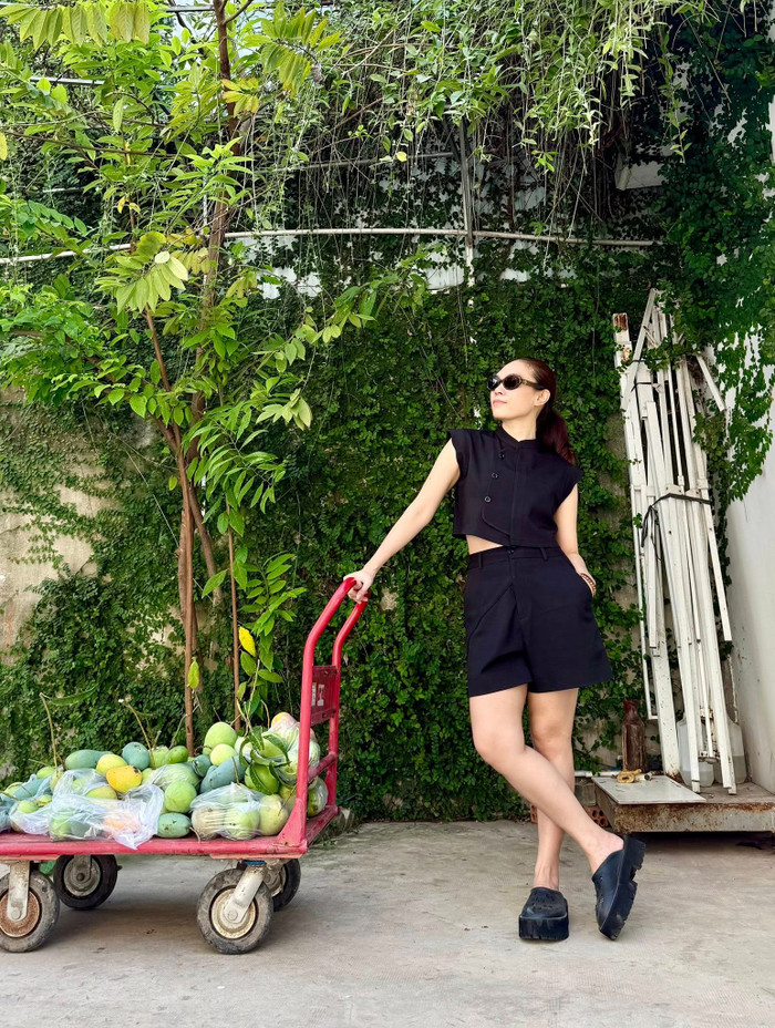 Ngay cả những set đồ monochrome (đơn sắc) màu đen, cô cũng chọn kiểu dáng hiện đại với áo croptop sát nách có cúc và quần short xếp ly đứng phom, mang lại vẻ ngoài sắc sảo, cá tính và cực kỳ sành điệu. Ảnh: FBNV