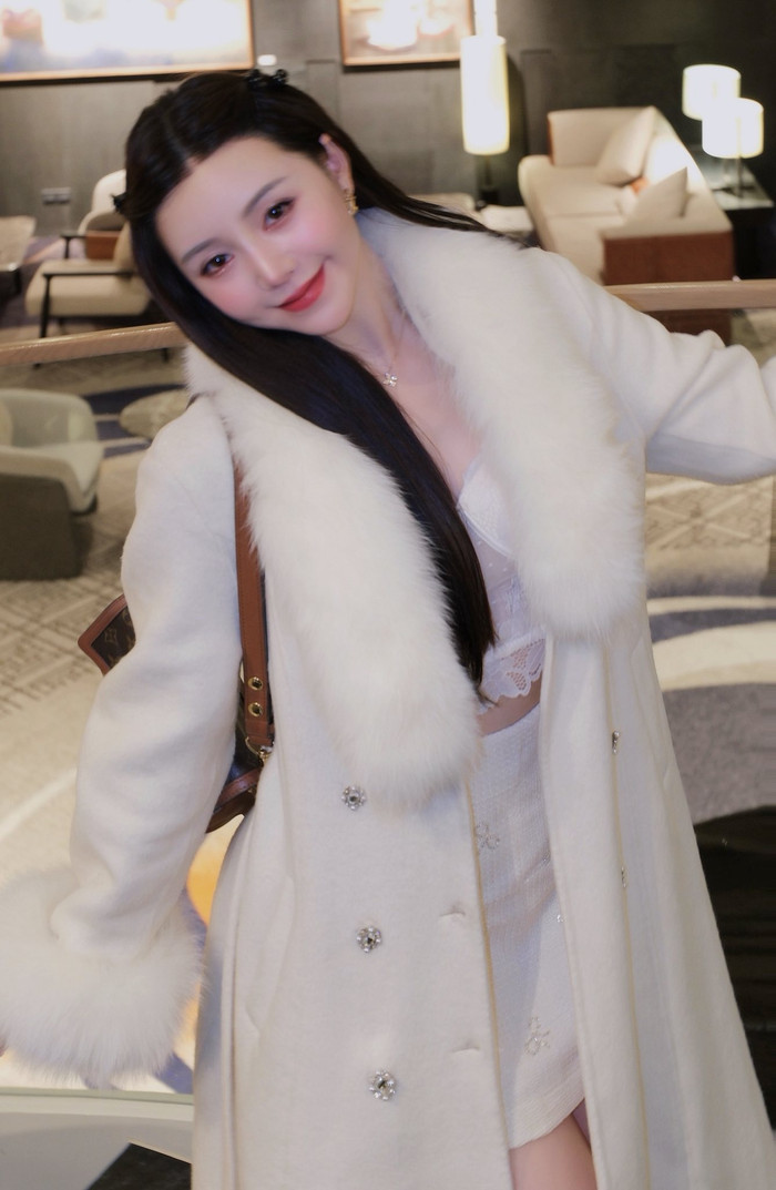 Quỳnh Kool khoe dáng và phong cách thanh lịch khi diện corset ren trắng kết hợp cùng chân váy dạ, bên ngoài khoác áo choàng cổ lông sang trọng (Ảnh: FBNV).
