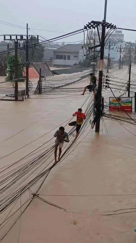 Người dân liều mình đi trên dây điện để thoát thân giữa dòng lũ khiến mạng xã hội xôn xao Ảnh 2