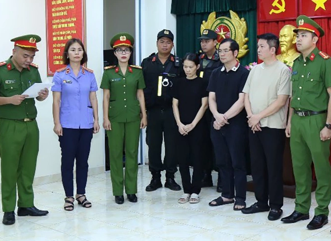 Các bị can Nguyễn Quốc Vũ (thứ 2, bên trái), Đinh Văn Liên và Nguyễn Thị Tuyến nghe công an đọc lệnh bắt. (Nguồn: VnExpress)