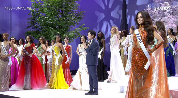 Khoảnh khắc Hương Giang đứng hàng đầu, dõi theo màn chia sẻ của ông Nawat trên sân khấu Miss Universe gây chú ý. (Ảnh chụp màn hình từ Grand TV)