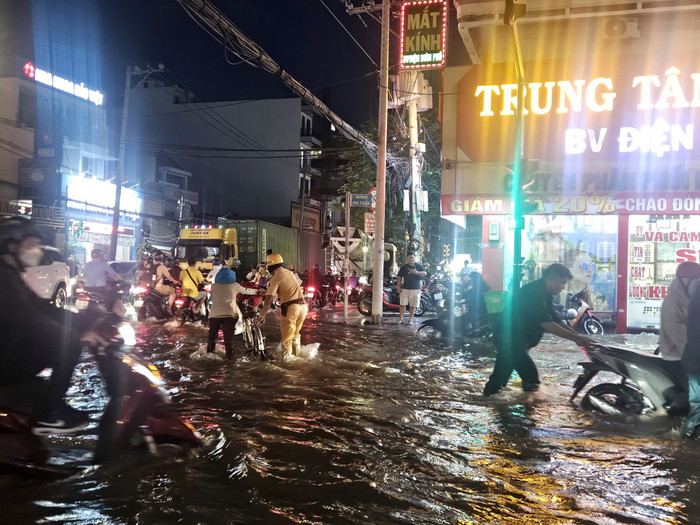 Lực lượng CSGT trực tại các chốt trọng điểm, sẵn sàng hỗ trợ người dân qua vùng ngập. (Nguồn: Công an Thành phố Hồ Chí Minh)