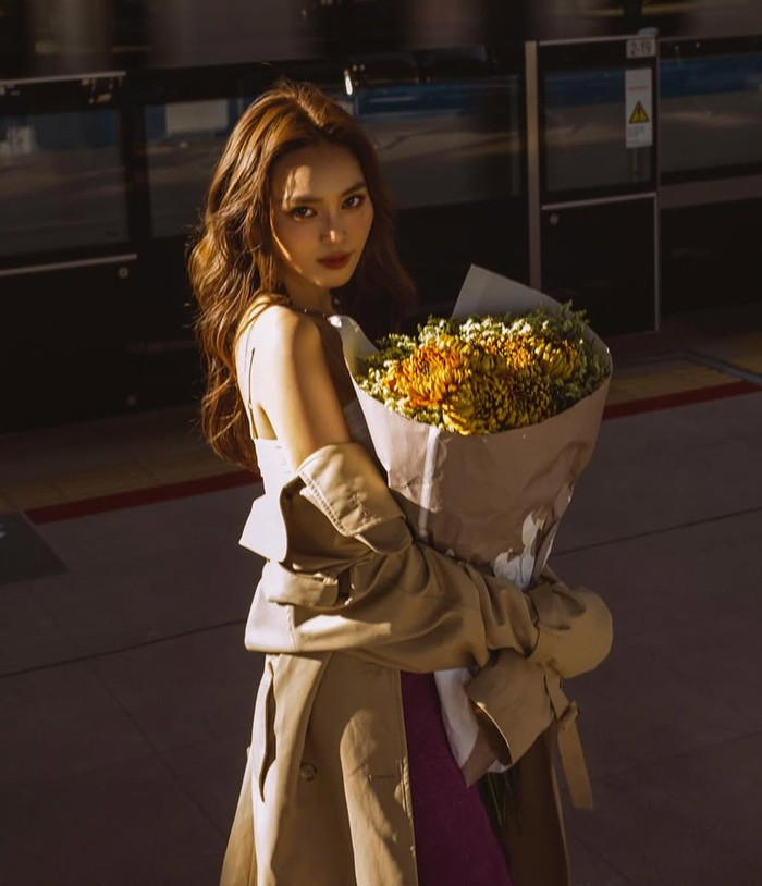 Ninh Dương Lan Ngọc luôn biết cách biến những khoảnh khắc đời thường thành sàn catwalk mini qua gu thời trang linh hoạt, kết hợp hài hòa giữa các item cơ bản và điểm nhấn tinh tế. Trong một bộ ảnh cách đây không lâu, nữ diễn viên xuất hiện tại ga tàu với vẻ ngoài thơ mộng, cầm bó hoa cúc vàng rực rỡ làm phụ kiện chính. Cô diện áo vest lửng màu be oversize từ chất liệu trench coat nhẹ nhàng, khoác hờ trên chiếc váy tube tím nhạt ôm sát, tạo nên sự tương phản màu sắc ấm áp giữa tông đất và tím lavender. Ảnh: IGNV