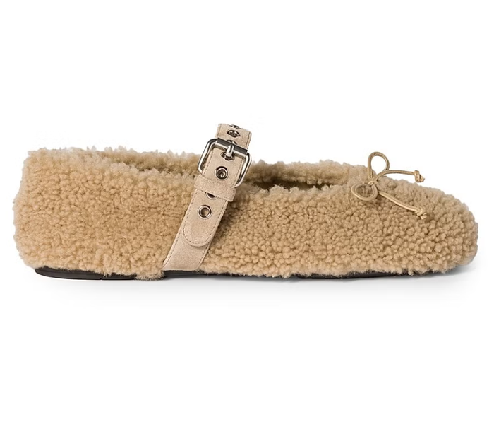 Thiết kế ballet của Miu Miu được làm mới cho mùa đông bằng chất liệu lông mềm ấm áp, kết hợp quai khóa bản lớn tạo điểm nhấn đúng tinh thần trẻ trung của thương hiệu. Mẫu giày có thể mang cùng tất hoặc không, và dễ dàng phối với set đồ len ton-sur-ton, chân váy denim hay áo len cashmere, tạo nên tổng thể vừa ấm áp vừa thời thượng. Ảnh: Elle