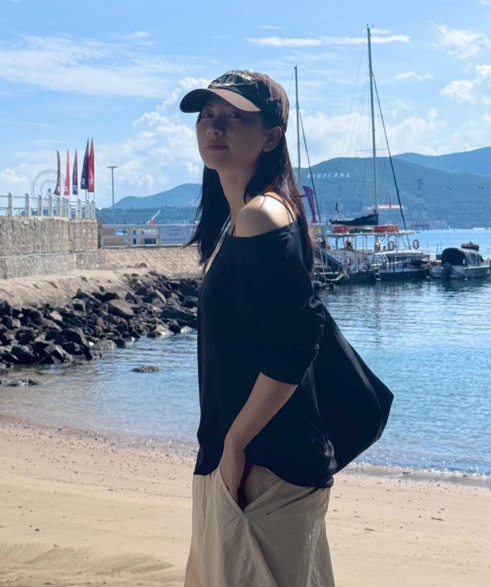 Trong một bức ảnh tại bãi biển, Phương Anh Đào chọn áo đen lệch vai với tay áo dài vừa phải, tạo cảm giác thoải mái dưới nắng gió. Áo có thiết kế rộng rãi, kết hợp với quần be rộng ống, trang phục này mang đến vẻ ngoài thư giãn, phù hợp cho những chuyến đi biển. Nữ diễn viên phối cùng chiếc mũ lưỡi trai họa tiết camo, thêm nét cá tính mạnh mẽ vào tổng thể. Phong cách này phản ánh sự ưu tiên của Phương Anh Đào cho các món đồ dễ di chuyển, không gò bó. Ảnh: FBNV