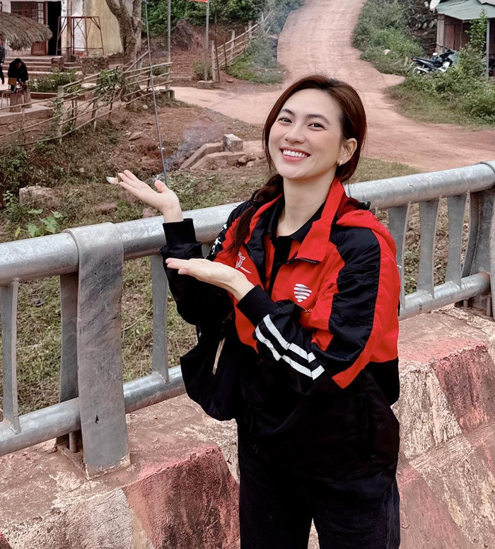 Trong buổi từ thiện gần đây, Phương Anh Đào diện áo khoác đỏ đen với sọc trắng ở tay, tạo điểm nhấn thể thao. Áo có cổ đứng và phần thân rộng, phối cùng quần đen ôm sát, giúp cân bằng giữa sự năng động và nữ tính. Túi đen đeo chéo nhỏ gọn, phù hợp cho việc khám phá địa hình gồ ghề. Ảnh: FBNV