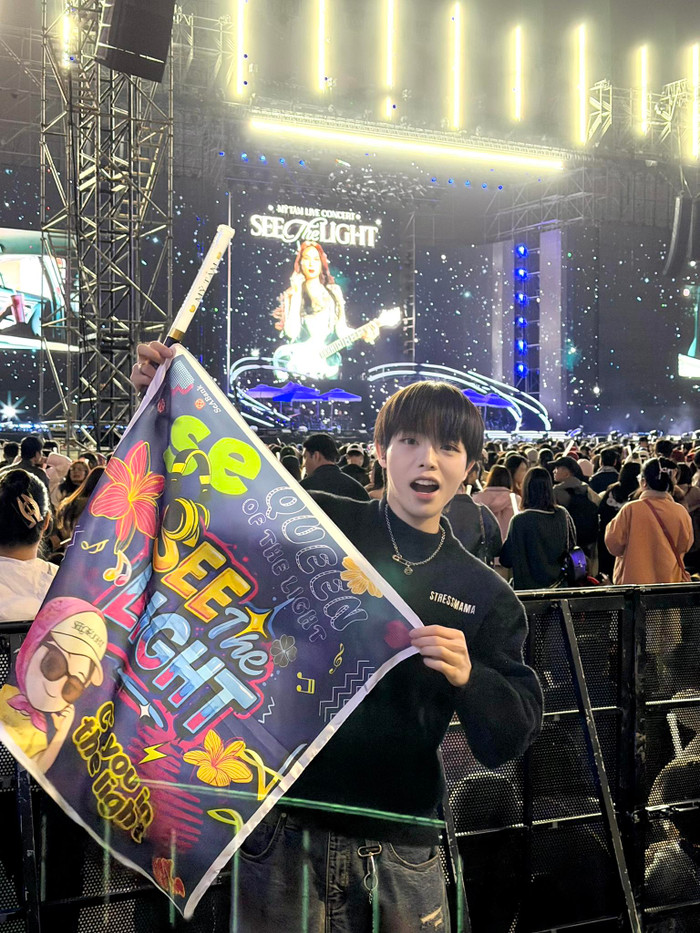 Trong khi đó, Đức Phúc lại chọn phong cách thể thao và năng động hơn với chiếc áo sweatshirt màu đen, đội mũ lưỡi trai và cầm khăn lưu niệm của concert. Ảnh: FBNV