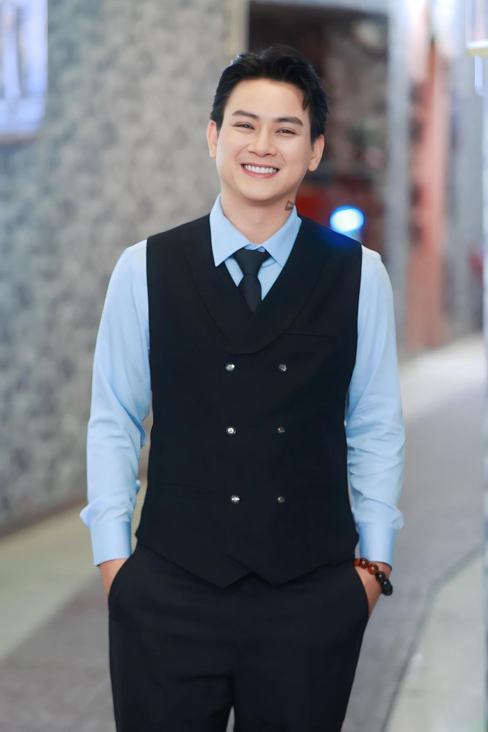 Trong các buổi biểu diễn trang trọng, Hoài Lâm thường chọn những bộ suit tối màu, được cắt may ôm sát để tôn dáng. Anh ưa chuộng những thiết kế cổ điển như suit đen với áo sơ mi trắng, cà vạt thanh lịch, đôi khi nhấn nhá bằng một phụ kiện tối giản như vòng tay. Chất liệu vải mịn, không quá bóng bẩy, giúp anh toát lên vẻ chuyên nghiệp, phù hợp với không gian ánh sáng nghệ thuật. Ảnh: FBNV