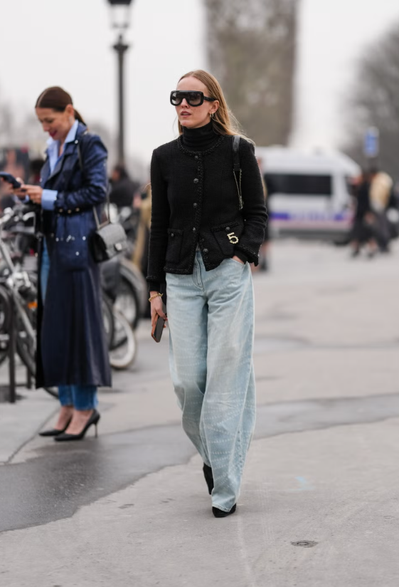 Một chiếc áo khoác không cổ mang phong cách nữ tính trở nên phù hợp với thời tiết se lạnh khi kết hợp cùng áo len cổ lọ mỏng màu đen. Set đồ tạo cảm giác chỉn chu, lý tưởng để diện đến văn phòng. Tuy nhiên, khi kết hợp với quần jeans dáng rộng và túi xách vai thanh lịch, tổng thể vẫn giữ được nét phóng khoáng, phù hợp cho những ngày cuối tuần. Ảnh: Harpers Bazaar