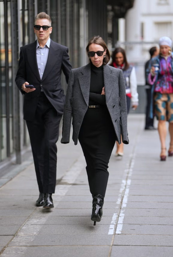 Để có set đồ mùa đông đơn giản nhưng sắc sảo, hãy khoác blazer bên ngoài áo len cổ lọ cùng chân váy ton-sur-ton. Thêm những phụ kiện nổi bật như thắt lưng kiểu dáng kiến trúc và boots bóng để tạo điểm nhấn, đồng thời vẫn giữ tổng thể tối giản, phù hợp để diện đến văn phòng. Ảnh: Harpers Bazaar