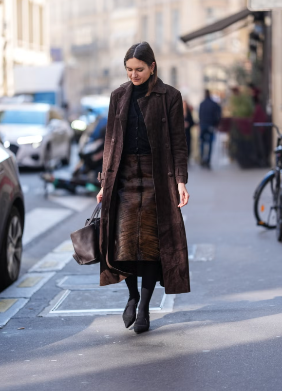 Một lần nữa, hãy thử phối các kiểu cổ áo khác nhau để tạo điểm nhấn thú vị. Chiếc áo len cổ lọ ôm vừa vặn có thể kết hợp cùng cardigan cổ V gân. Hoàn thiện set đồ với những món da lộn tông nâu, như trench coat và chân váy midi. Ảnh: Harpers Bazaar