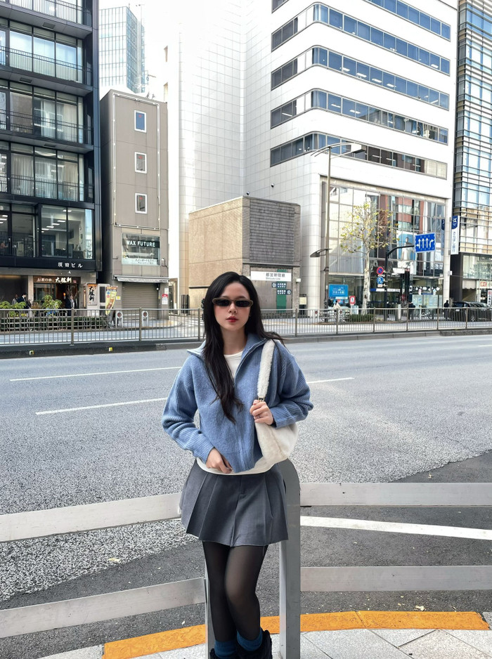 Midu lấy tay kéo vạt áo khoác che bụng khi được chồng chụp ảnh. Ảnh: FBNV