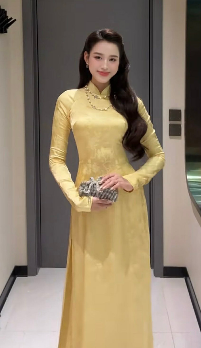 Đỗ Thị Hà thu hút sự chú ý khi lựa chọn áo dài truyền thống, kết hợp cùng phụ kiện túi cầm tay hiện đại.